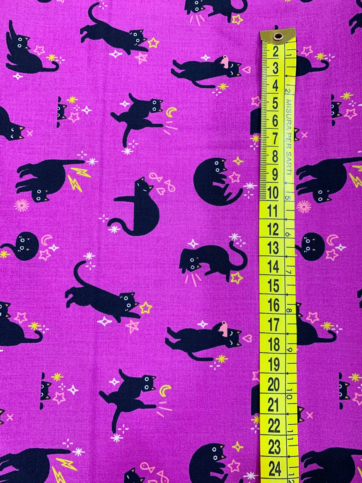 Dettaglio tessuto cotone americano viola ciclamino Freaky Familiars Witchy Catwalk con stampe di gatti neri e simboli magici esoterici per cucito.