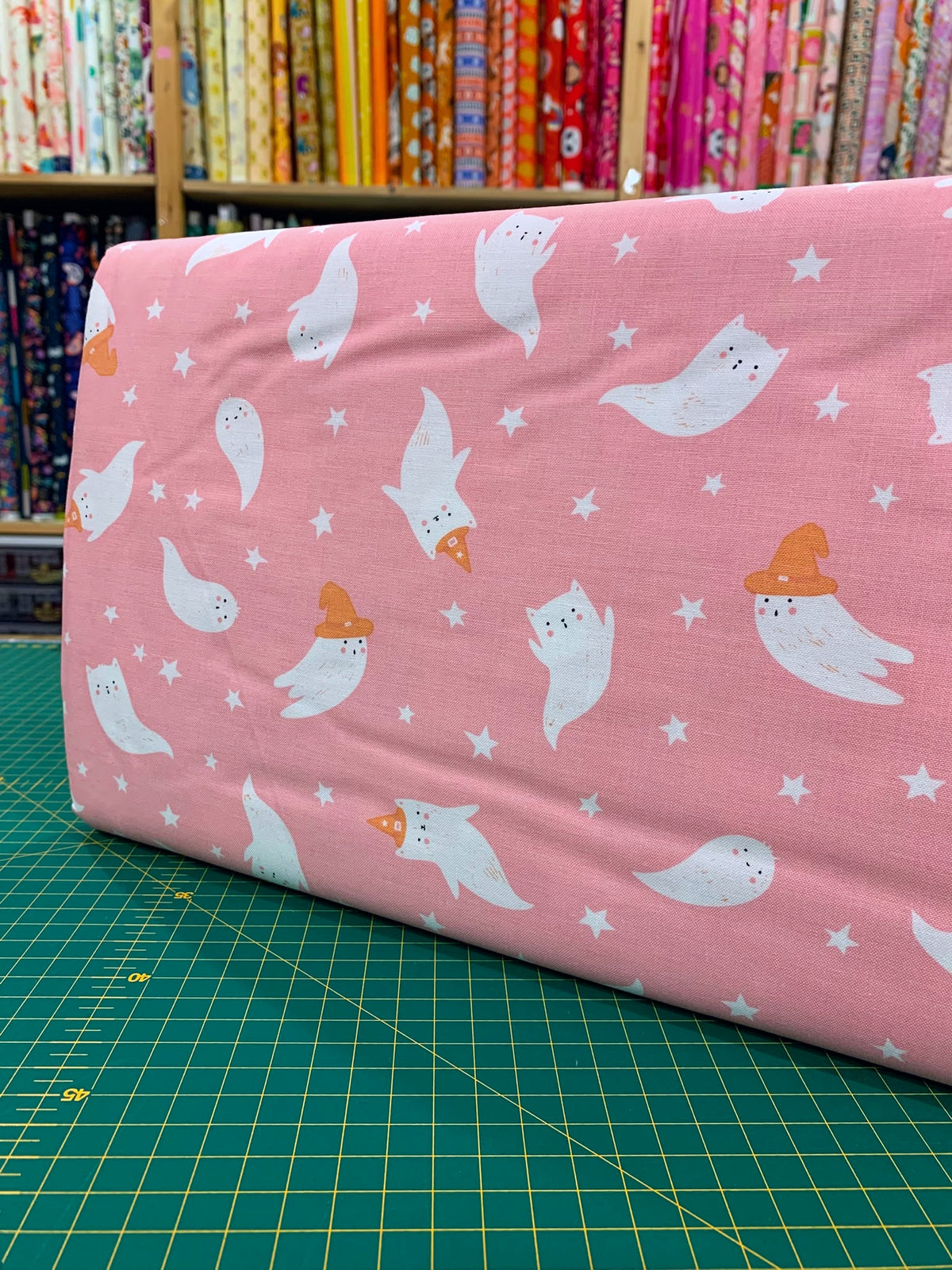 Dettaglio tessuto cotone americano sfondo rosa Moda Fabrics Purrs And Boos con stampe di dolci fantasmini di Halloween.