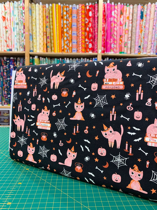 Dettaglio tessuto cotone americano nero Moda Fabrics Purrs And Boos con stampe pop di gattini neri di Halloween, zucche arancioni e fantasmini.
